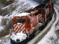 When I first showed a picture from this vantage point in public (at the AltaMont rail gathering in Montana), folks that were familiar with the area could not believe that this was in Calgary. It is one of my favorite locations.
This westbound sulphur train rumbles through the S curve just east of Brickburn Siding. About 2/3 back will be a robot car and another couple of DS-40's.