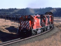 Westbound CP train passing Glenbow siding (Blocked by train). The reason for the icicle clearing car may be seen at the far left - auto racks.