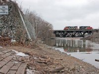 <b> No Fishing, No Trespassing </b> CN 556 screams past with two idler cars in tow back to Oakville on this cold winters day.