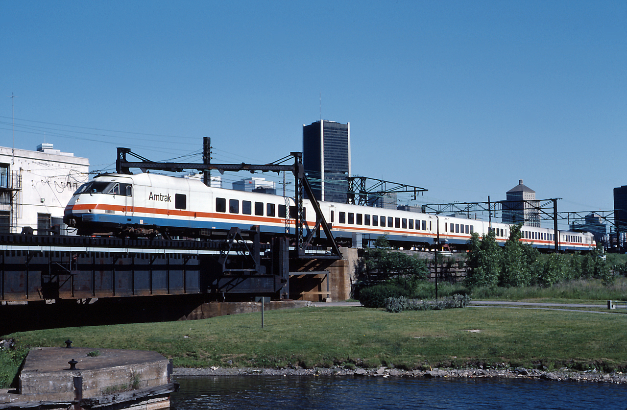 Amtrak 28 heads for Central Station with Amtrak Turboliner 156 doing the honours.  From a similar vantage point, Michael Berry caught Amtrak 68 crossing the canal 29 years later in August 2015 (Time sure flies!), comparing the two shots, quite a few things have changed in the area.  
 http://www.railpictures.ca/?attachment_id=21034