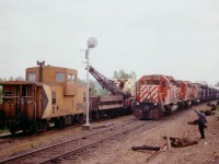 Reasonable entertainment on a crappy (but warm) dull day; seemingly a specialty of mine :o) this time out driving around featured a stop at Pointe au Baril to see 'if anything was happening'. CP 7090 was there; crane & van. Since I had brought the girlfriend along; the rail worker decided he could pass some time showing the little lady how things worked while they waited out a northbound freight. He then proceeded to operate the equipment; moving the bucket around, etc., and keeping her entertained while I watched in amusement. After about 20 minutes it was train time. Too bad it was so lacklustre a day out there; but the scene with CP 5726, 5744 and 4725 was well worth the wait.