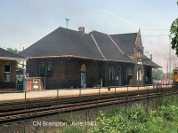 The old GTR/CNR Brampton Station, downtown on a sunny day as a pair of VIA Budd RDC's accelerate eastbound out of the station platforms bound for Toronto.
<br><br>
According to various historical sources, the Grand Trunk Railway built their Toronto-Stratford line through Brampton in 1856, and the arrival of the railway gave rise to more commercial and industrial activity and allowed the town to flourish. The current elegant brick station was built in 1907 by the GTR, after a push by a local town councillor for better train service and a more up-to-date station to replace the original one.
<br><br>
A few "tenant" changes took place over the years: the station was operated by CN until VIA took over their passenger services. GO Transit introduced their new Georgetown Line commuter service in April 1974, originally operating its ticket booth out of the former Express building on the left (note green door and fencing preventing entry without a ticket, before the POP era). Today the station building proper is home to both VIA and GO, still in regular use over 100 years since it was built.
