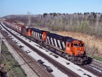 CN 2000, CN 2338 and an unknown SW1200RS leads an eastbound manifest through Les Cedres on the Kingston Sub.      