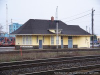 This station was originally built at a location known as Freeman Junction. The city of Burlington had not met it's urban sprawl when the Hamilton and Northwestern Railway intersected that of the line built by the Great Western Railway. All was eventually consumed into the Grand Trunk network, and ultimately, ended up under CN ownership when the Grand Trunk went belly up. 

Much has changed at this junction since that time. The station was clad with insul-brick at one time, but that was removed and the CN semi-restored the building to house what I had been told was their 'test facility'. Little did I know that it's future was in doubt, with the expansion of Go Transit's trackage in this area. This meant the removal of the station only months later. 

It was hoisted onto a trailer and sat on beams for about 8 years at the fire hall a short distance away on Fairview Street. As of writing this (2015) - it's full restoration is almost complete, as it took the city council sometime to come up with a plan for it. 

Here, on this drab dreary spring day in 2005 - it sits with the Halton Subdivision visible in the foreground (former H & NW trackage to Georgetown, Milton, and points north to Allandale and Meaford), as well as with the Oakville Subdivision in front of the station. 
