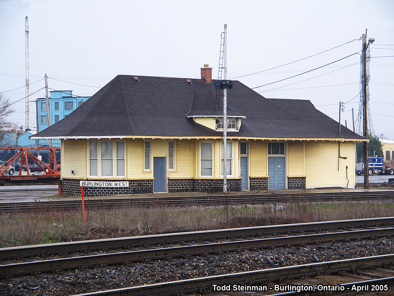 This station was originally built at a location known as Freeman Junction. The city of Burlington had not met it's urban sprawl when the Hamilton and Northwestern Railway intersected that of the line built by the Great Western Railway. All was eventually consumed into the Grand Trunk network, and ultimately, ended up under CN ownership when the Grand Trunk went belly up. 

Much has changed at this junction since that time. The station was clad with insul-brick at one time, but that was removed and the CN semi-restored the building to house what I had been told was their 'test facility'. Little did I know that it's future was in doubt, with the expansion of Go Transit's trackage in this area. This meant the removal of the station only months later. 

It was hoisted onto a trailer and sat on beams for about 8 years at the fire hall a short distance away on Fairview Street. As of writing this (2015) - it's full restoration is almost complete, as it took the city council sometime to come up with a plan for it. 

Here, on this drab dreary spring day in 2005 - it sits with the Halton Subdivision visible in the foreground (former H & NW trackage to Georgetown, Milton, and points north to Allandale and Meaford), as well as with the Oakville Subdivision in front of the station.