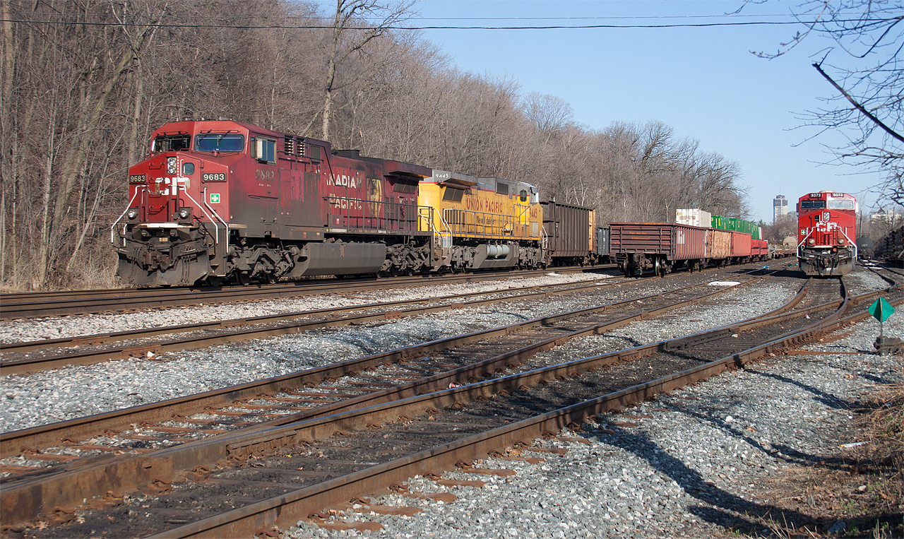 CP 9683 and UP 9445 roll past Kinnear Yard in Hamilton as CP 9373 awaits the call the duty.