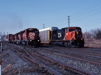 On a quiet Sunday morning, CN 332 with the CN 5688 slows down to enter the yard at Oakville where they will set out some autoracks for the Ford plant before continuing eastwards to Oshawa.  As CN 332 eases through the crossover, CP 153 wastes no time accelerating by on the south track with 5 SD40-2's, making a mile a minute down the high speed Oakville Sub.  