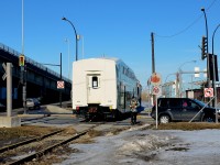 <b>GO Transit car through the crossing.</b> GOT 2439 is being pushed to CAD (Canadian Allied Diesel) by CN 7020 & CN 7017 where it will be refurbished. A crewmember is flagging the busy St-Pierre crossing. This spur is no longer in use since a bit over a month now.