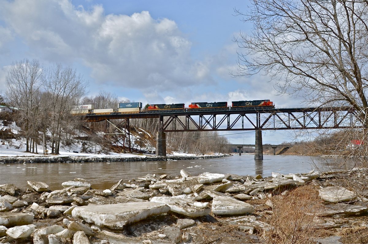 Sometimes you get lucky. I ran out of a friends car and squeezed off just a single shot off before the train sped by. CN 120 heads east through Saint-Léonard-d'Aston with a trio of GE products (CN 2234, CN 2204 & CN 2604) pulling a long string of containers bound for Halifax.
