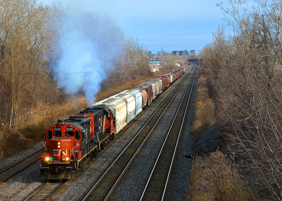 Smoke show! Montreal-area transfer CN 500 smokes it up while approaching Taschereau Yard with 30 cars. Power is GP9 CN 7062 & GP38-2 CN 4732.