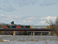 A pair of ex-Oakway SD60's (CN 5482 and CN 5400) leads CN 401 through Daveluyville as it passes over the raging Bécancour River.