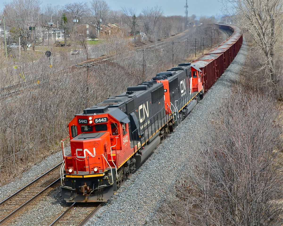 A pair of ex-Oakway SD60's (CN 5442 and CN 5468) heads west through Beaconsfield with a loaded ballast train.