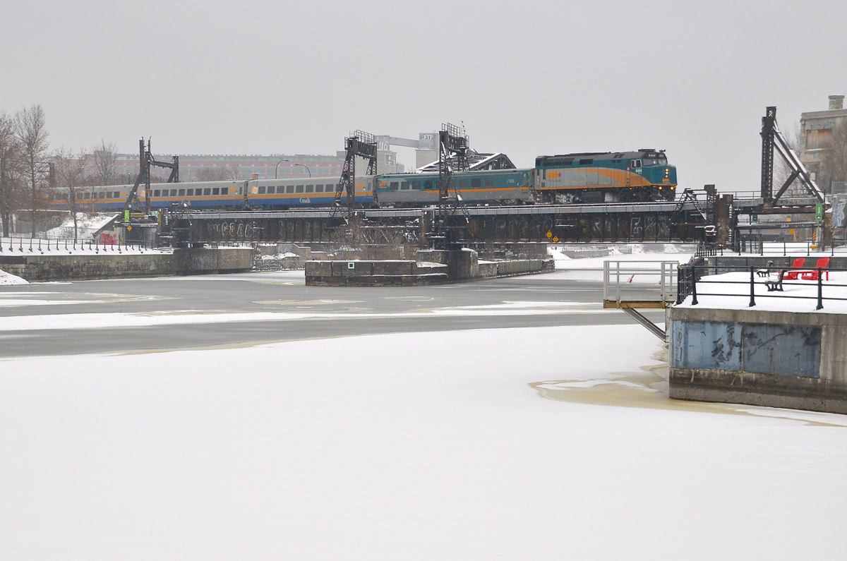 A bit more snow. VIA 62 is crossing the Lachine Canal on its way to Montreal's Central Station as a bit more snow falls. In the foreground is the ice and snow covered Peel Basin.