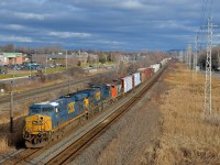 <b>Two CSXT GE's, with a zebra behind them.</b> CN 327 is through Pointe-Claire with a CSXT ES40DC & AC6000CW leading a CN GP38-2W (CSXT 5422, CSXT 643 & CN 4795). For the record the GP38-2W was online. It will get dropped off at Coteau. It was cloudy for a bit before this train arrived but the sun came out at the right time. 