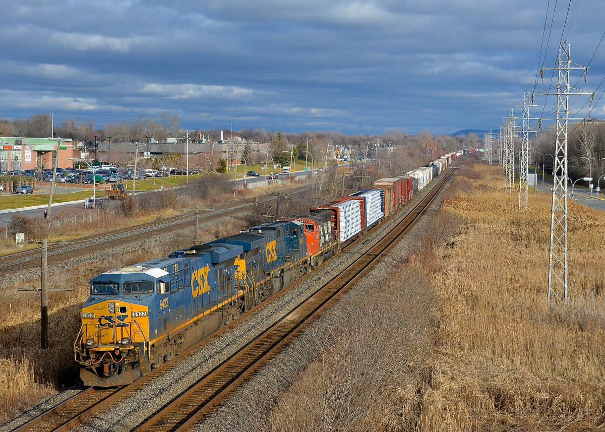 Two CSXT GE's, with a zebra behind them. CN 327 is through Pointe-Claire with a CSXT ES40DC & AC6000CW leading a CN GP38-2W (CSXT 5422, CSXT 643 & CN 4795). For the record the GP38-2W was online. It will get dropped off at Coteau. It was cloudy for a bit before this train arrived but the sun came out at the right time.