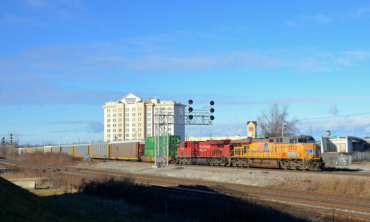 A single well car up front. CP 142 is through Dorval with a single well car up front (and more further back) as well as a UP leader, with ES44AC's UP 5532 & CP 8954 for power.