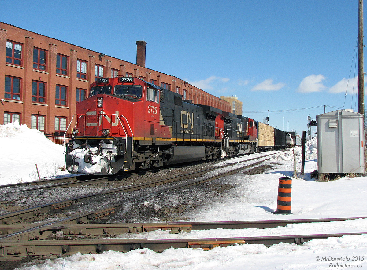 As a contrast to Bill Thomson's excellent photo of VIA 83 at Brampton diamond *here*, here's a more modern view of the same spot: CN freight #385 heads westbound through town, with GE C44-9W's IC 2726 and CN 2690 about to start hammering the diamond on the north track of the Halton Sub. The former CP line in the foreground now belongs to the Orangeville Brampton Railway (as the OBRY Owen Sound Spur) and sees use only twice a week. At the time, CP was still sending maintenance crews to regrind the diamonds from wear every so often, and CP trucks parked around the diamond area was a common occurrence.