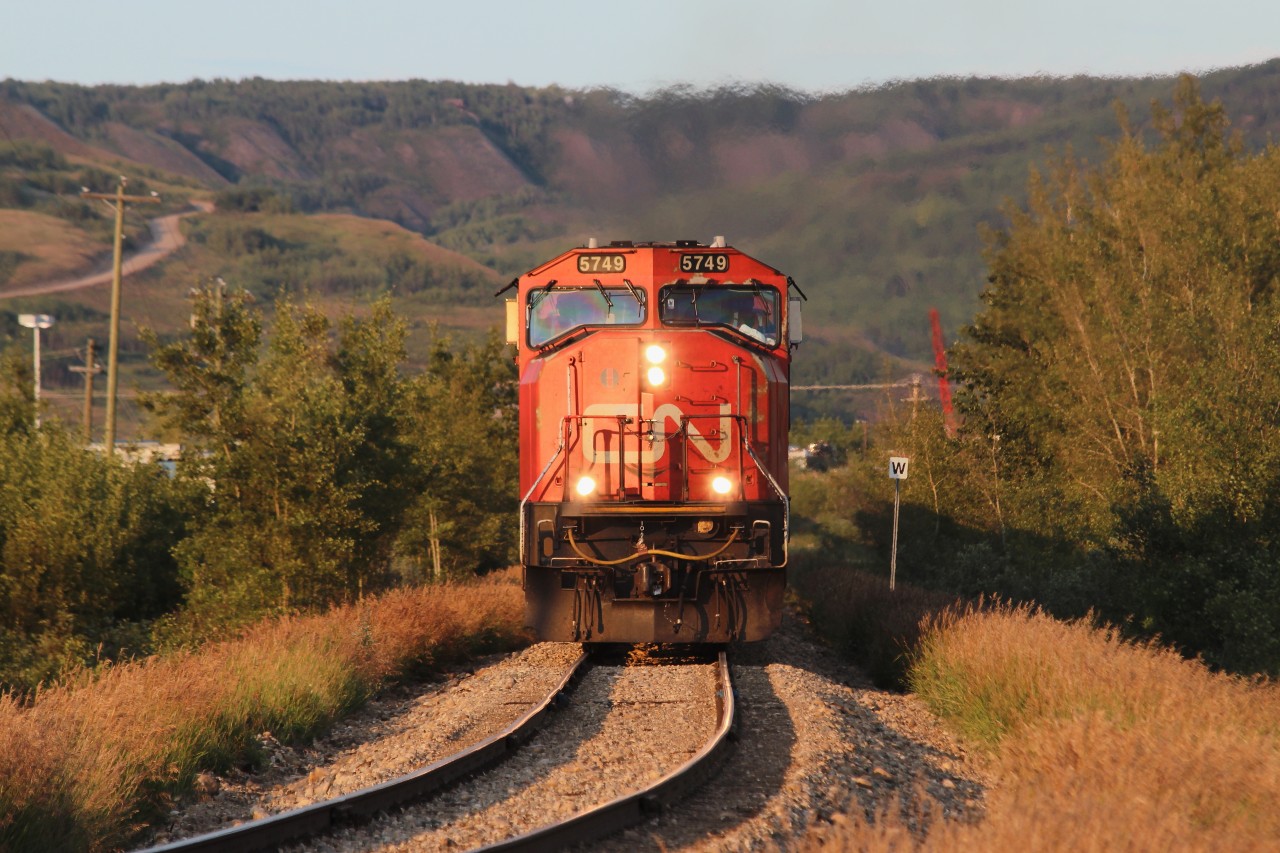 CN 506 makes it's way up the 2.2% grade towards Roma Junction terminal with a very long train today. The setting July sun at 9pm made this shot possible.