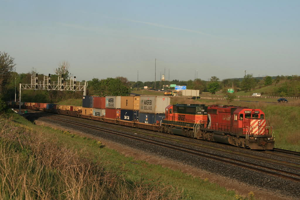 CP 255 with CP 5997 and BNSF 6919 repaying some HP hours...heads east on the CN just after sunrise.  Shot from the berm...in the days I could drive my car up to this spot. I notice some industrious railfans have now planted "lounger" chairs here :)