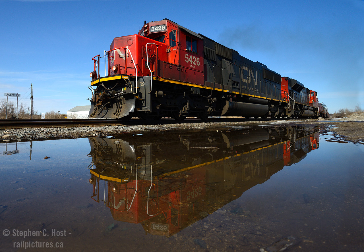 There used to be a station where that sign is at left... and it would have looked good... but spring has .. sprung and ponds of melt are everywhere providing some reflective opportunities. Interestingly enough CP train 246/7 had this pair for a few days.. or a couple weeks .. and I only went out to get it once - this was it for me.
Some great stuff from the past, a small distraction for our regulars who may not have seen this stuff:
 Hooping the Pickup at Guelph Jct - Bill Thomson 
 Earl Fitzpatrick hooping orders - a great winter photo  by James Adeney
For more.. hit 'search' or see suggested photos on this page.