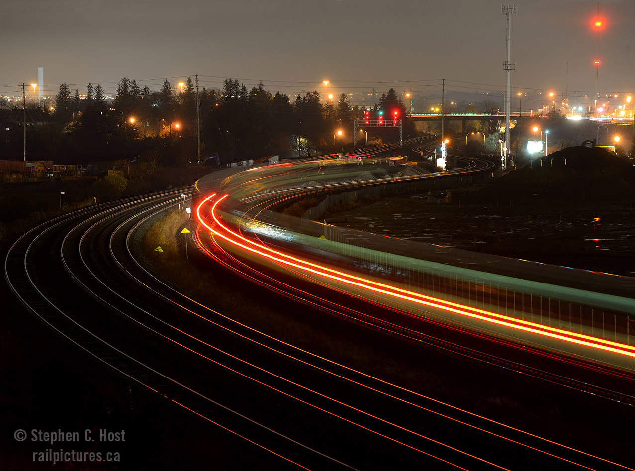 There's a certain allure to quiet, easily accessible locations that provide us photographers opportunities for study of our craft, and Hopkins St is one of these places. Shootable from north and south sides, from sunrise to sunsets.. this location has it all, and even provides an opportunity for night photography that I could not resist. 

I made the trip to Ottawa and Back on the 10th to visit with a friend, having been up since 0445 I was quite tired, 9 PM by the time I arrived at Hopkins St on my westward journey. I got the tripod out and see what I could do , and this was my best result. One friend of mine who saw this shot commented that he grew out of this phase of photography - truth is I never did much night photography until fairly recently, so I guess I haven't grown out of it yet!. I enjoyed taking this photo very much.
But why have there been so many photos from this location lately?This overpass is closing, permanently, and being demolished scheduled to be closed this spring as soon as the road seen in the distance by the shoo-fly is completed. Get out there while you can.. there aren't many places like this.