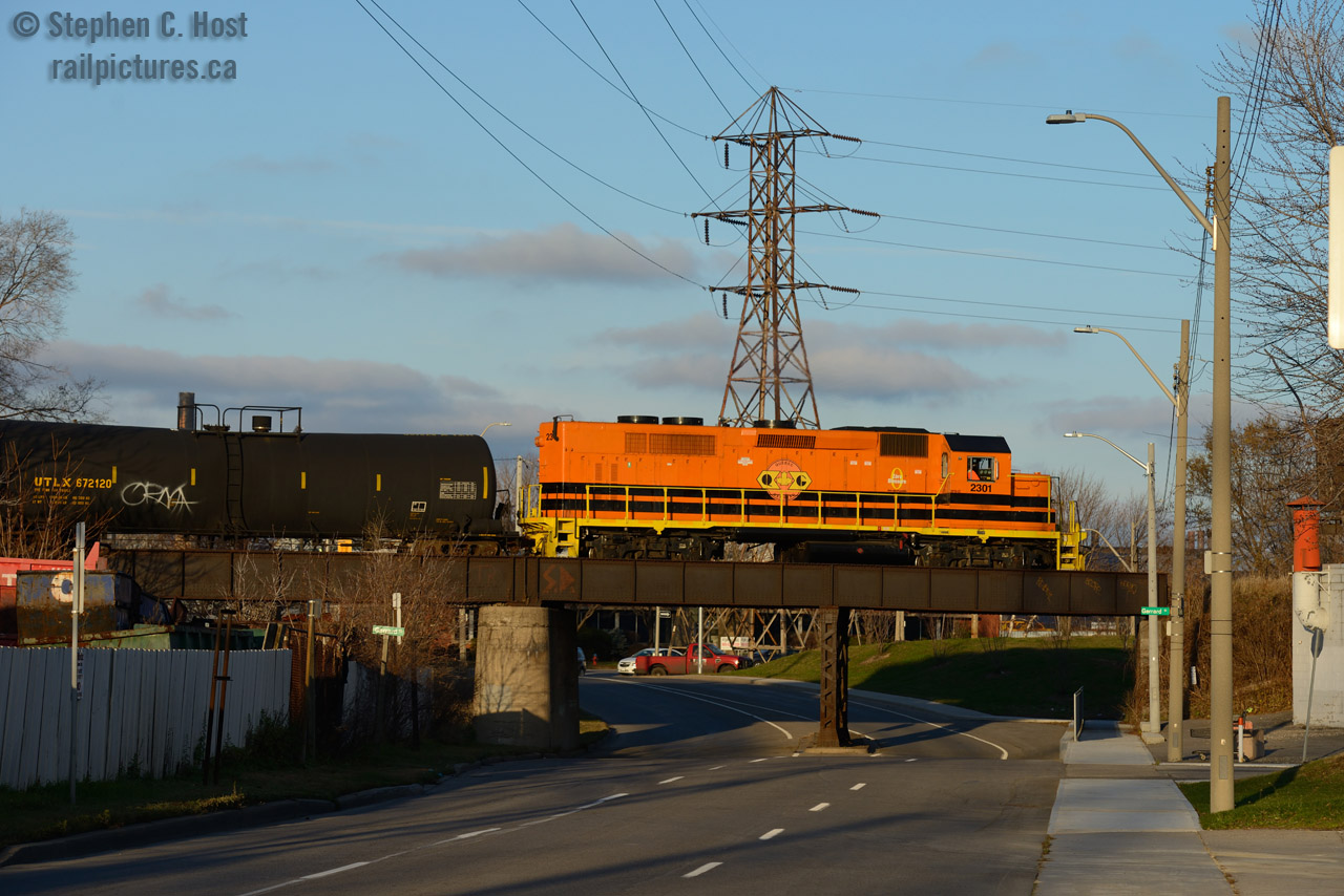 In the last rays of a late November sun, it's difficult to find a shot when the shadows are sooo darn long, but this scene worked out perfectly. The HAM 1400, otherwise known as the "far east job" is eastward on the N&NW spur with *60 cars*, having stalled trying to pull out of the yard, they got a shove from RLK 4003, as their train was just too heavy.
The far east, as it is known on the SOR consist of the Strathearne yard area (Columbian Carbon, Vopak, Westray, A&M Metals, plus much more) and the new-ish port area along the QEW. This job runs daily usually in darkness.
Sharp eyed readers should notice the ancient railway/road bridge is awfully wide... almost as if it may have been used for something else - indeed - this bridge was built to allow the Hamilton Radial Electric Railway's double track main line to pass under.... which you can see here - this photo on Birch Ave (as shown above): here  Look closer, there are still Trolly Wire insulators and wire guides mounted on the bridge..