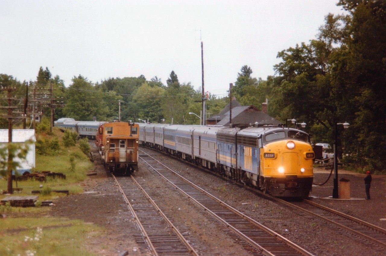 Warm overcast day at Parry Sound, the Toronto edition (#9) of the "Canadian" northbound is stopped at the CP station for servicing and perhaps even a passenger or two. Power is VIA 6519 and 6631. My notes indicate that is CP 8747 behind the van on the left, work train tied up for the day.