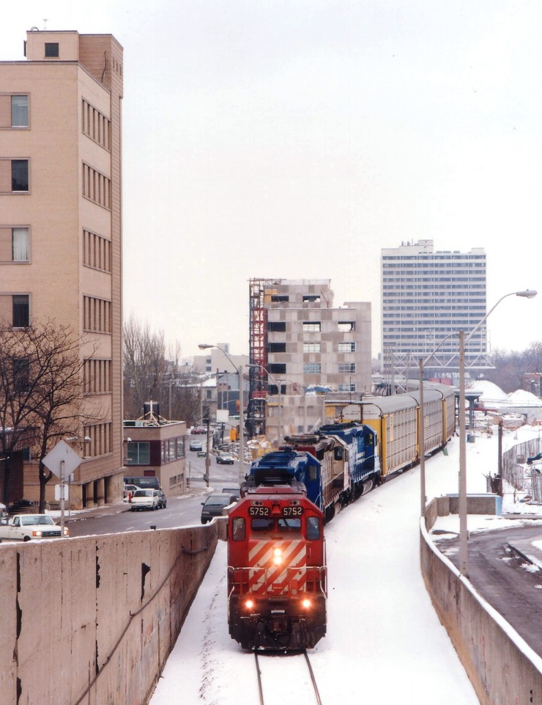 A rather interesting CP #523 snakes thru downtown Hamilton past the Art Deco-style TH&B station in this image taken from overhead where the line goes thru Hunter St. tunnel.  Nice power set: CP 5752, CRL 0608, SOO 6608 and CR 5299. (The CRL is Conrail Leasing, an arm of the CR system)  Note the area being readied for increased GO service; trainset staging area under construction as well as the old station restoration, evident by all the scaffolding on the left side of the building in this view.