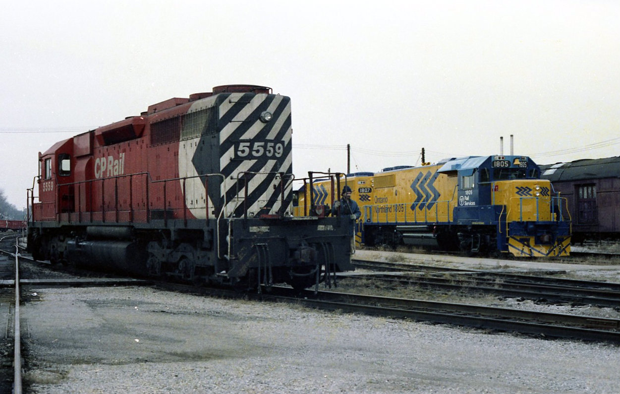 Saturday December 18th 1982. sitting in the lunch room in the Quebec street round house relaxing thinking the shift was over. At 6;45 the shop foreman called. The yard master wants an extra yard  sap, can you service the 5559 and let me know when your finished.  Seen here reversing around the back lead SD40 5559 passes two new ONR GP38-2,s delivered from GMD during the evening before. Two small things of note   , The ditch lights on the ONR 1805 are still covered and painted blue. And the old stripping from the gray and maroon days is showing threw on the rear buffer plate of 5559 . The cover over the air intake on 5559 behind the cab was to stop snow from entering and plugging up the baggie filters. This was applied to CP SD40 and dash 2 models.