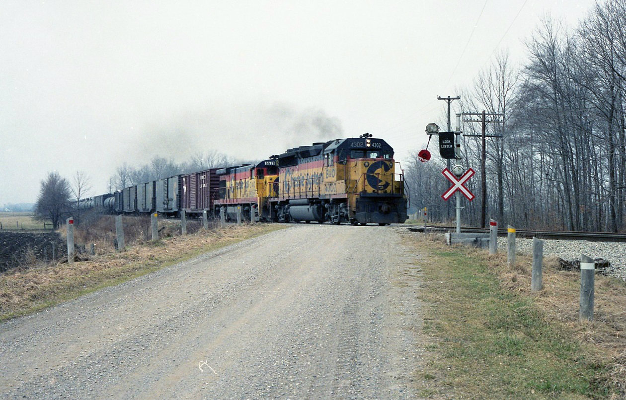 GP40-2 4302 and GE B30-7 5529 are just outside ST Thomas on the caso sub . This photo was taken in March of 1987 but the second unit has already been renumbered for the CSX, which to my understanding wasn't incorporated til August of 87. ????   And what must have been one of the last wig wag crossing protections in Ontario.