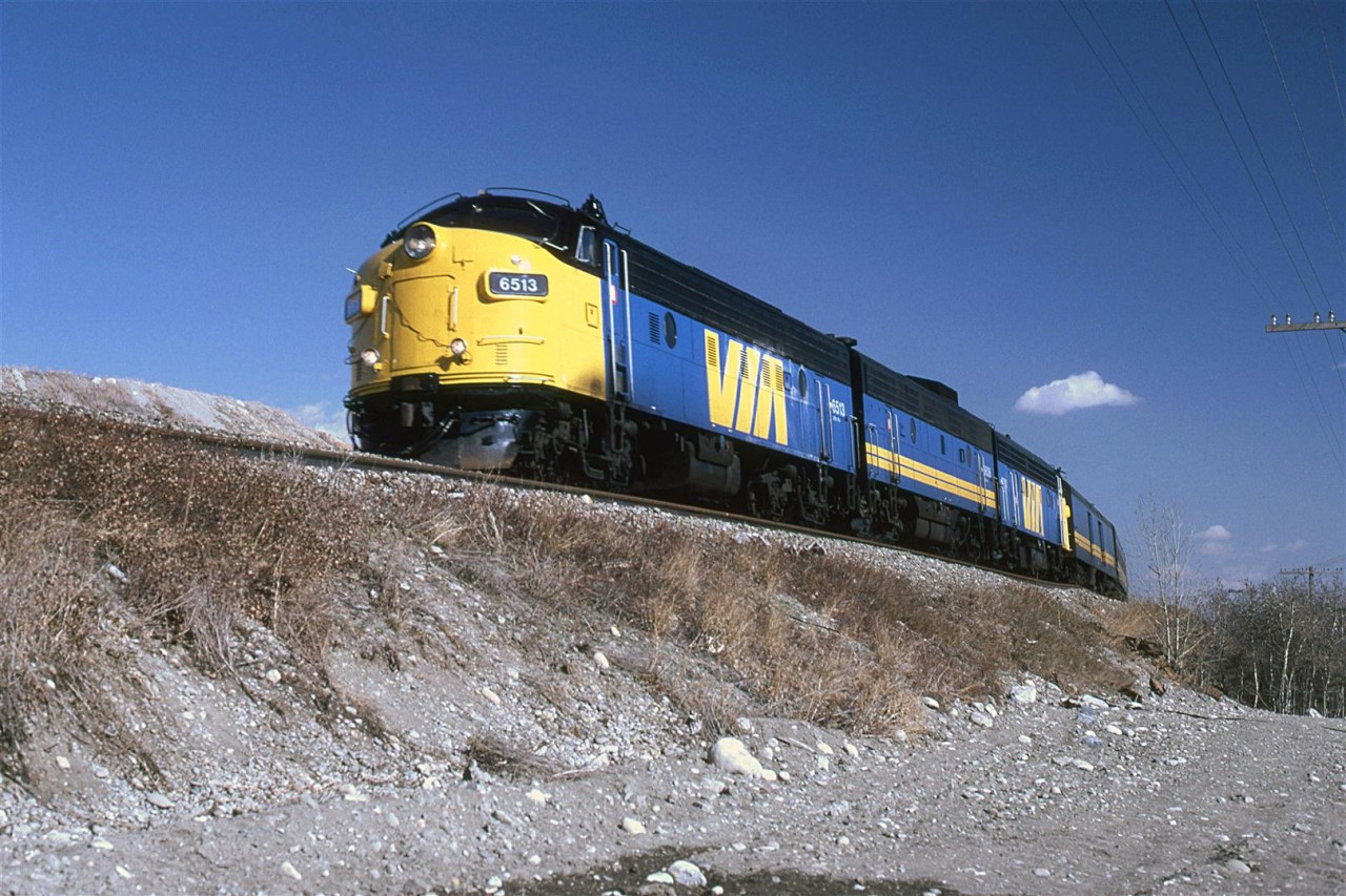 The westbound "Canadian" rounds the curve near the Bearpaw Dam in the Bow River. This is just west of Kieth yard. Some spoils from a large gravel pit may be seen on the horizon in front of the train.