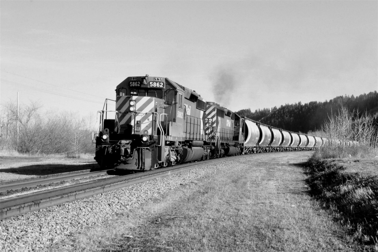 It is possible that this is the "Exshaw Turn" because the head end cars look to be destined for the LaFarge Cement plant. The timing, however, is a little late at 1650hrs (That is 3 to 4 hours late), and 6 axle power is rare to say the least. Perhaps this is a through train that will simple drop the cars in the siding before continuing west.
