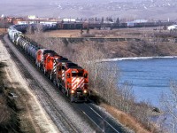 This eastbound train must have been at Kieth while the westbound "Canadian" passes, because it was only 15 minutes between the two appearances. Of note on this train, is the fifth engine. It looks to be a GP-9 and it is covered in white powder. Perhaps it was stationed at the LaFarge cement plant in Exshaw for a while.Right behind are are several tank cars used to haul molten sulphur. Although not uncommon, most sulphur out that was was solid "bits" poured into open gondolas. Behind the sulphur cars, there appear to be several cement hoppers - likely from Exshaw. Then there are box cars, likely used for wood products and finally, the train appears to be filled out with grain hoppers.