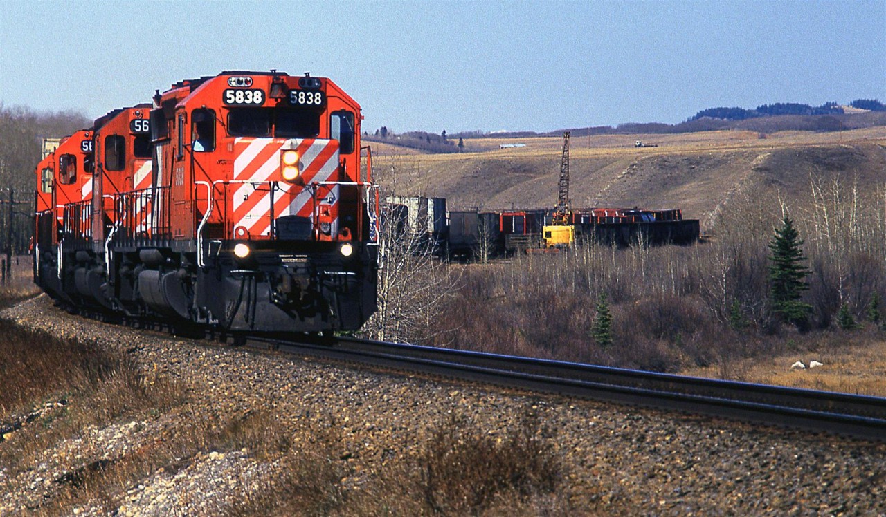Another eastbound hot and cold train - High priority stuff up front and junk tacked on. The number boards on the 5838 don't appear to be original, or CP font for that matter.
In the short Mitford sidings are some old gondolas, most likely used for MOW and an old crane (And before anyone asks, I did not stop to photograph the crane. I was young and naive.).
I Googled Mitford a while back and learned that there were a couple of small coal mines here at one time.They extracted coal for the RR. I believe the mines would have been on the hill to the left and hehind the locomotives. Not much remains, apparently.