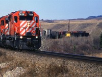 Another eastbound hot and cold train - High priority stuff up front and junk tacked on. The number boards on the 5838 don't appear to be original, or CP font for that matter.
In the short Mitford sidings are some old gondolas, most likely used for MOW and an old crane (And before anyone asks, I did not stop to photograph the crane. I was young and naive.).
I Googled Mitford a while back and learned that there were a couple of small coal mines here at one time.They extracted coal for the RR. I believe the mines would have been on the hill to the left and hehind the locomotives. Not much remains, apparently.