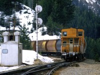 The tail end of an eastbound empty grain train is about to duck into the Upper Spiral Tunnel, just west (RR east) of the east switch of Yoho. As usual, there is still quite a bit of snow around in mid April.