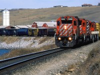 This eastbound manifest is coasting along Bearpaw reservoir in west Calgary. The "Bearpaw" sign indicates that the next location (a siding) is "Bearpaw". I can't be certain, but on the back side of the sign, it might read "Kieth". The attractive barn and farm are still there now.
 