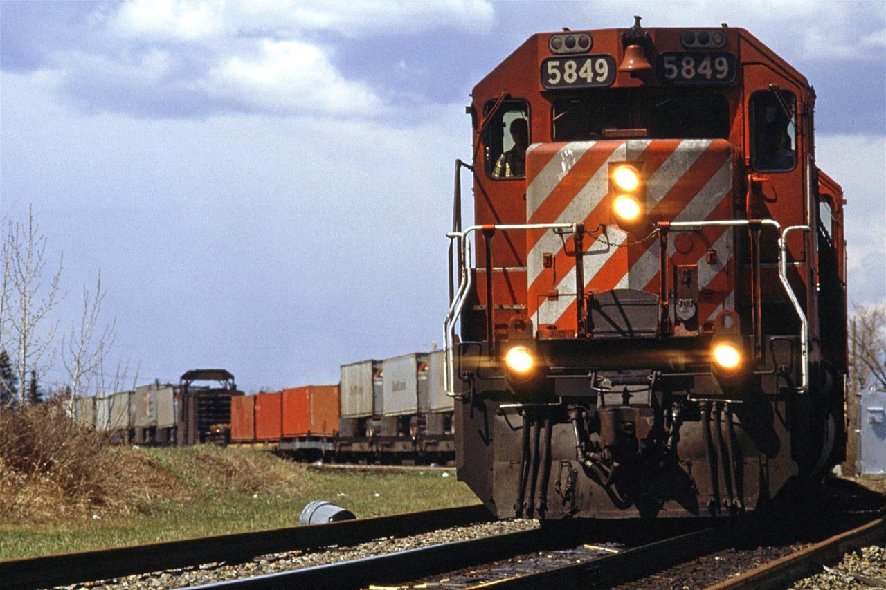 Another shot on Edworthy Park. An eastbound intermodal cautiously works through the work limits of a rail replacement crew.