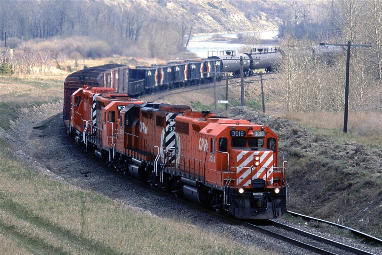 The outbound Exshaw Turn is approaching Kieth yard. Perhaps that is where the box cars will be dropped? The aggregate cars are likely headed to Exshaw to be loaded, and the tank cars might be going to the Copithorn Spur for liquid sulphur loading. I wish that I had paid attention to what was in those tank cars.
It's May 9 and the grasses are starting to show a touch of greening.