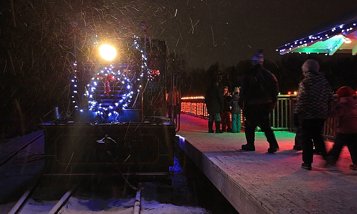For the 2015 Portage Flyer Christmas runs a snow squall blew in across Fairy Lake buffeting riders and Christmas lights alike, so much so that the strands of lights on the locomotive got blown off-kilter. No big deal, the passengers were well dressed for the occasion knowing they'd be travelling in open-air coaches and the locomotive still looked festive!
