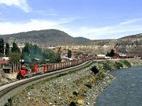 A westbound CN grain train rolls through Ashcroft BC in the Thompson River Valley. CP main is on opposite side of river