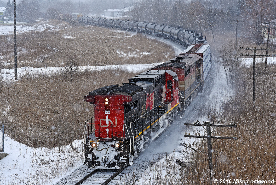 It happened again, this time due to a locked axle on the original leader, which was set off 'somewhere up north' according to the crew. Here as CN 2115 and BCOL 4617 are about of pass under hwy 48 in Mout Albert, they accelerate both after going in for 317 at Zephyr and in deference to the hard slog up the moraine set to begin momentarily. Within two miles they'd be down to about 1mph, exhaust screaming towards the heavens, though muted by the snowfall. Quite a show. 1352hrs.