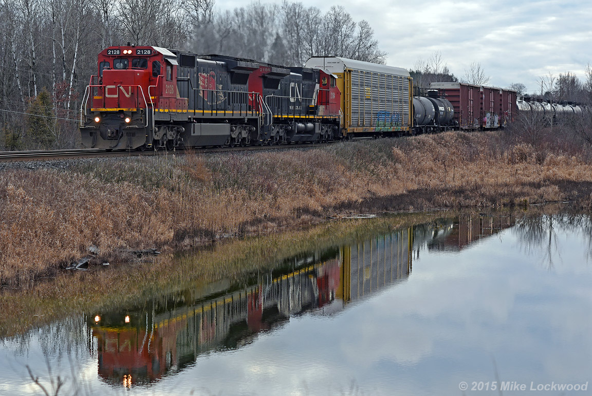Reflected in still waters outside of Salem, CN 2128 and 2184 lead 306's train down the Kingston Sub. 1527hrs.