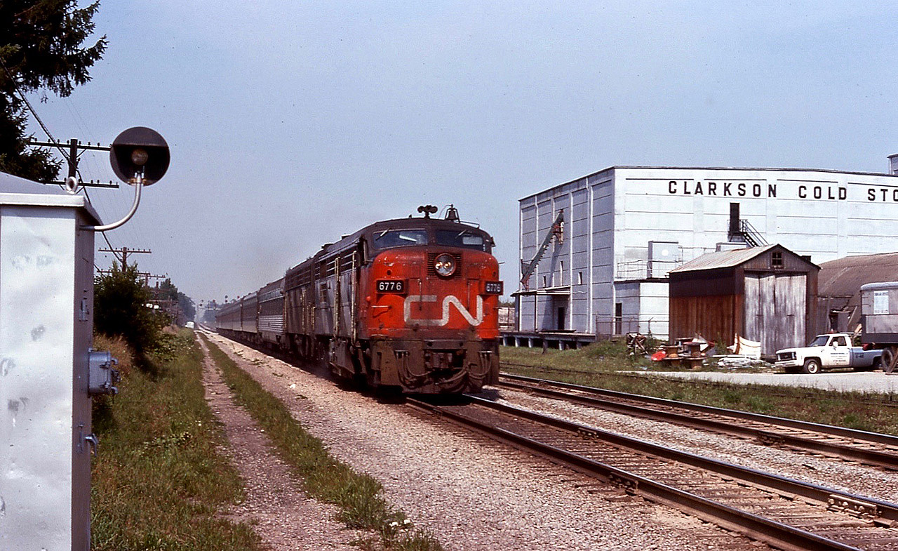 CN FP4A leads a westbound passenger over the crossing at Clarkson road. The coach trailing the power is a former Reading 'Crusader' observation car.