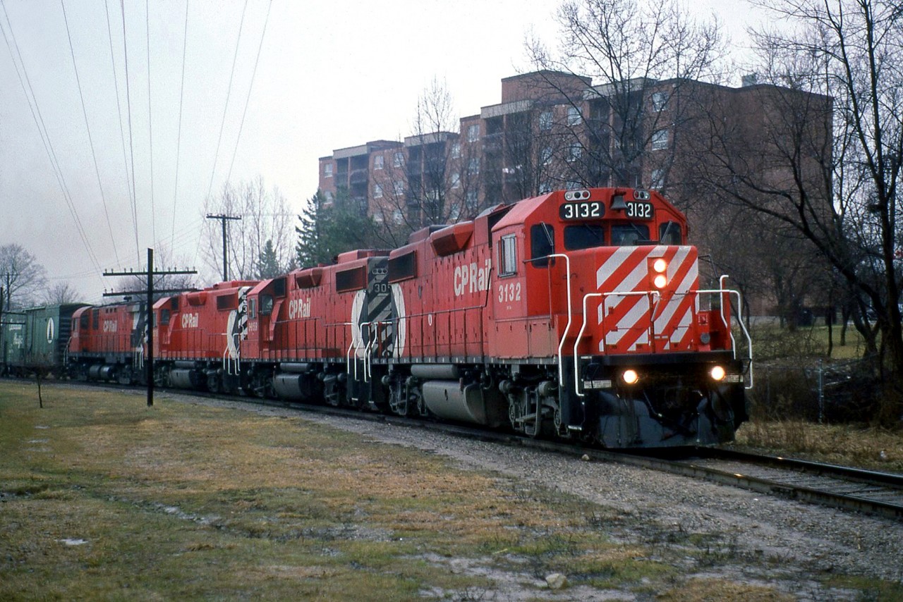 CP's "Moonlight" heads north at Bythia Street through Orangeville, leaving town enroute to Owen Sound on the Owen Sound Sub. Power today are GP38-2's 3132, 3059, 3076 and C424 4250.Today, the line to Owen Sound from Orangeville has been abandoned and removed just north of Orangeville, but the line south to Streetsville survives as the Orangeville Brampton Railway.