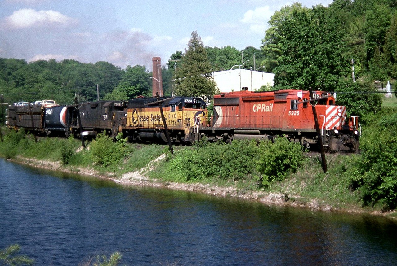 Rolling west past the ponds at Campbellville, CP SD40-2 5935, B&O GP40 3724 and CR GP38 7747 (still in PC black) head west on the Galt Sub towards Guelph Junction in June of 1985.