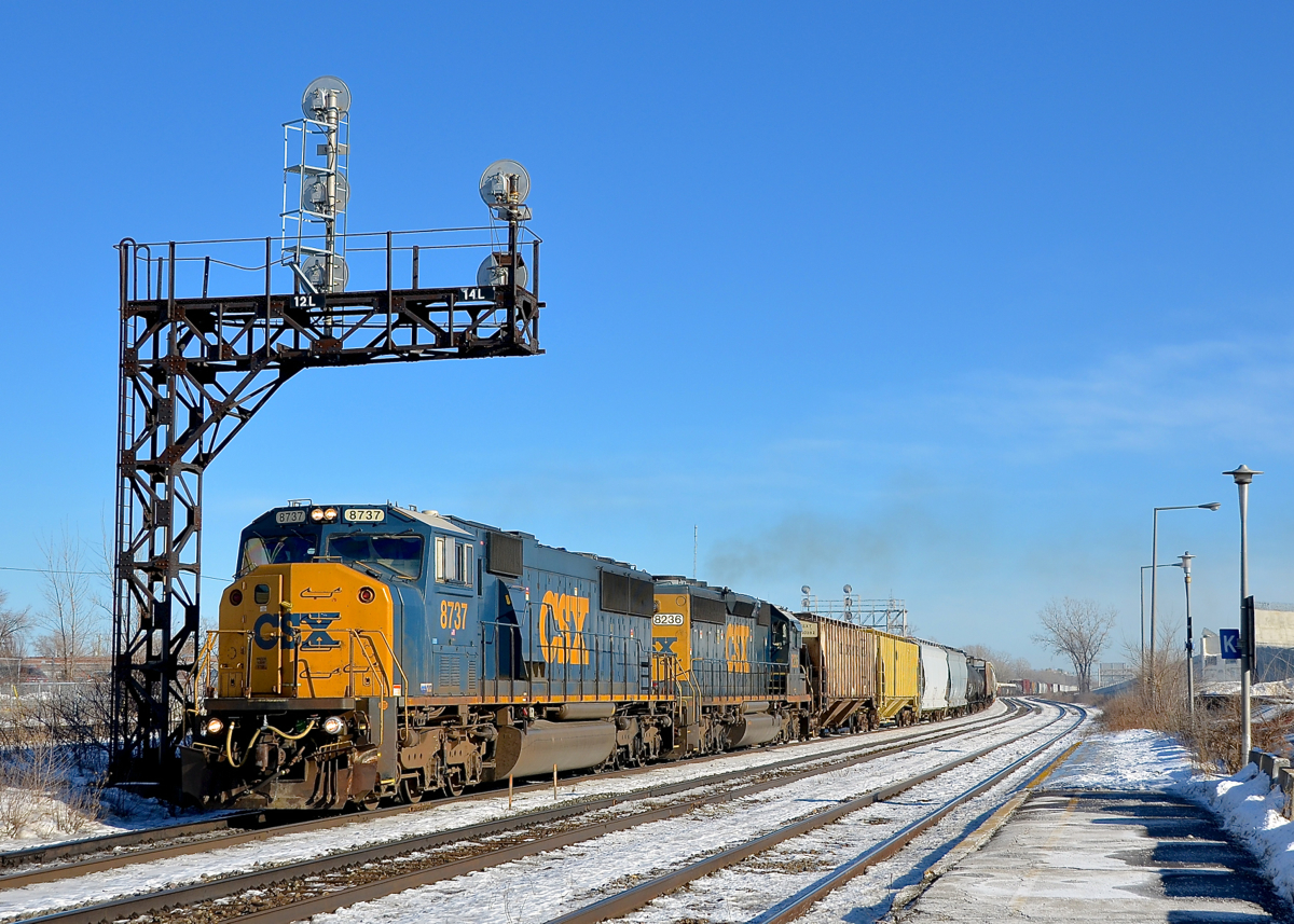 Ex-Conrail and L&N EMD power. SD60I CSXT 8737 (ex-CR 5614) and SD40-2 CSXT 8326 (originally a straight SD40, LN 1250) lead CN 327 underneath the signal gantry near the VIA Dorval Station.