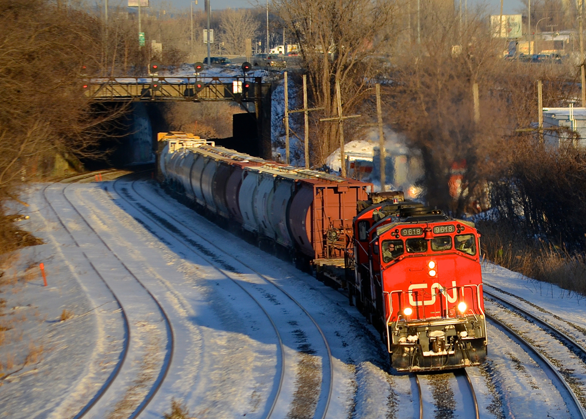 CN 527 into the sun. CN 527 heads west through Montreal West during some nice winter light. Leading is CN 9618, with CN 7275 & CN 7226 out of sight.