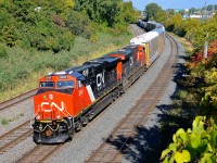 <b>A novelty at the time.</b> At the time this photo was taken in September 2014, CN's ES44AC's were rare in Quebec, whereas now many, many trains have them as power. They are also nowhere near as clean as they were soon after being built Here CN 401 heads west through Montreal West with two ES44AC's (CN 2865 & CN 2852), the former being brand new at the time.