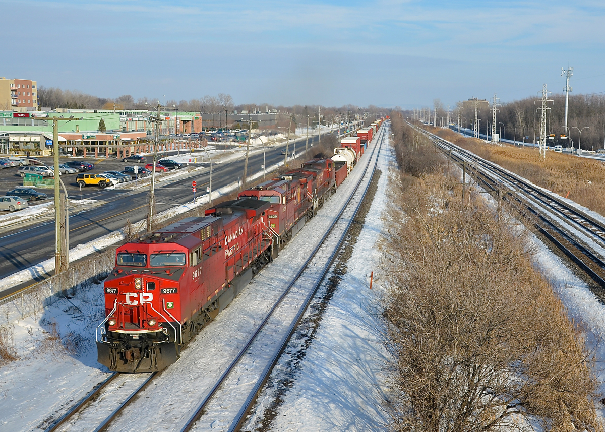 Repainted AC4400CW leading. Repainted AC4400CW CP 9677 is leading two less fresh AC400CW's (CP 8639 & CP 8570) on CP 119, westbound through Pointe-Claire on a sunny afternoon.